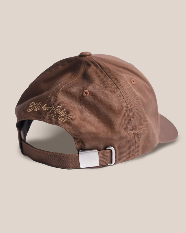 Коричневая бейсбола с гнутым козырьком и металлической застежкой